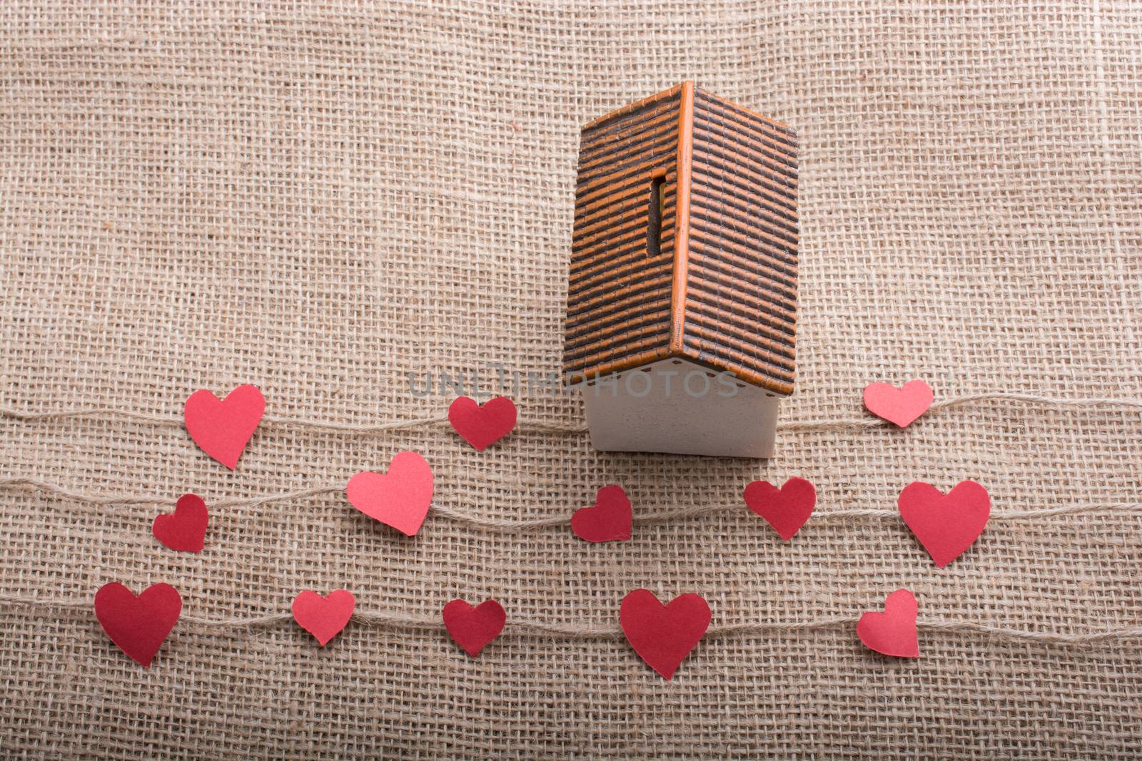 Heart shaped icons and paper house on linen threads