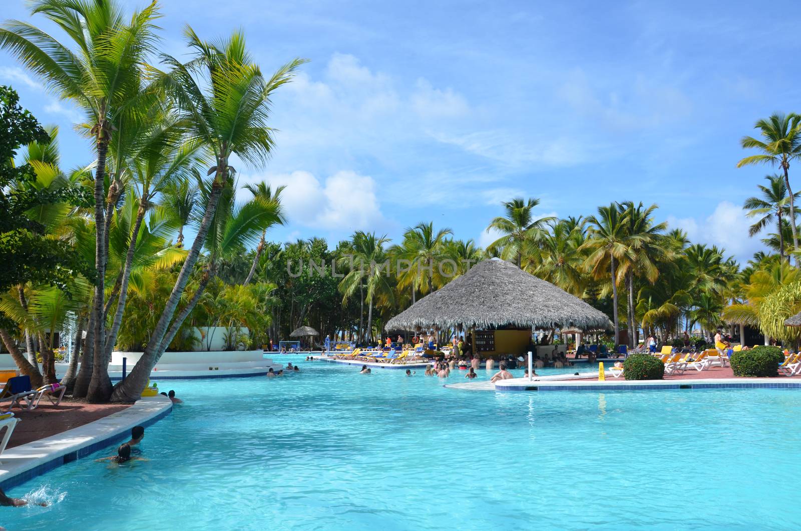 Beautiful luxury swimming pool at a tropical resort, People relax at the hotel. by claire_lucia