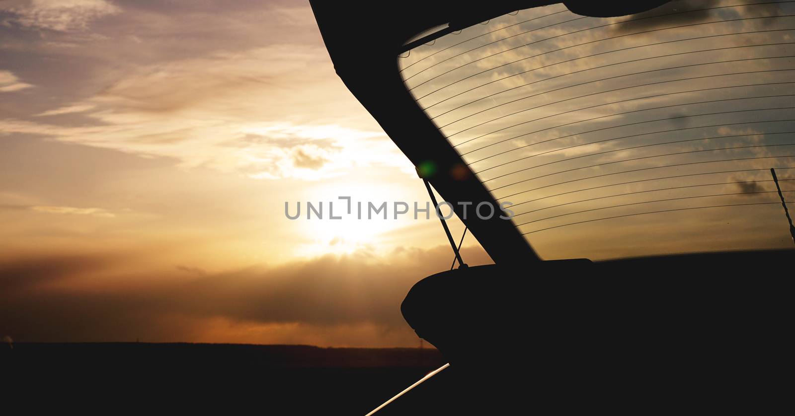 Outdoor car trunk at sunset, photo against the sun - travel concept