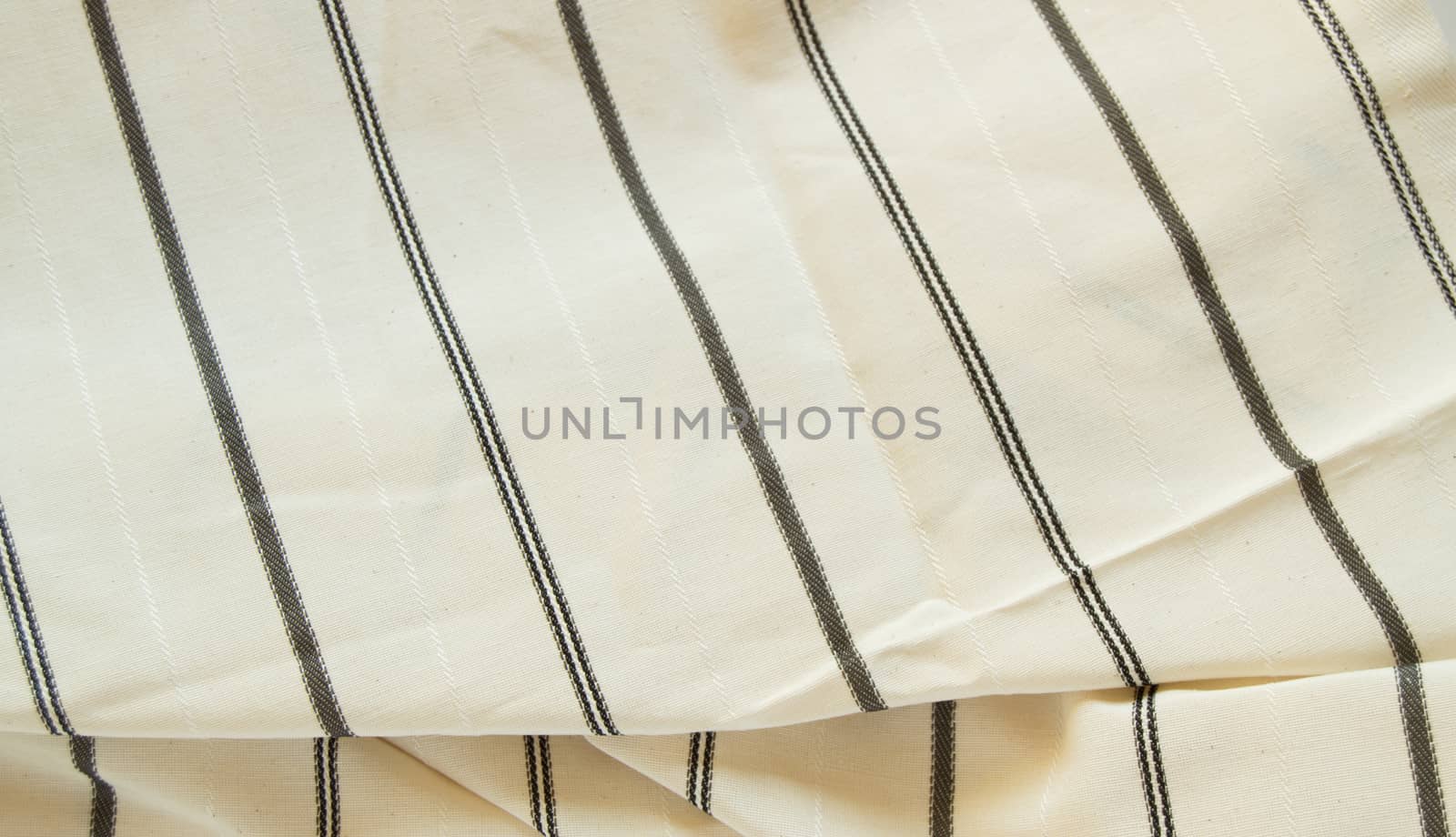 Beige linen fabric with black stripes, the texture of the fabric, the weaving industry or material for sewing