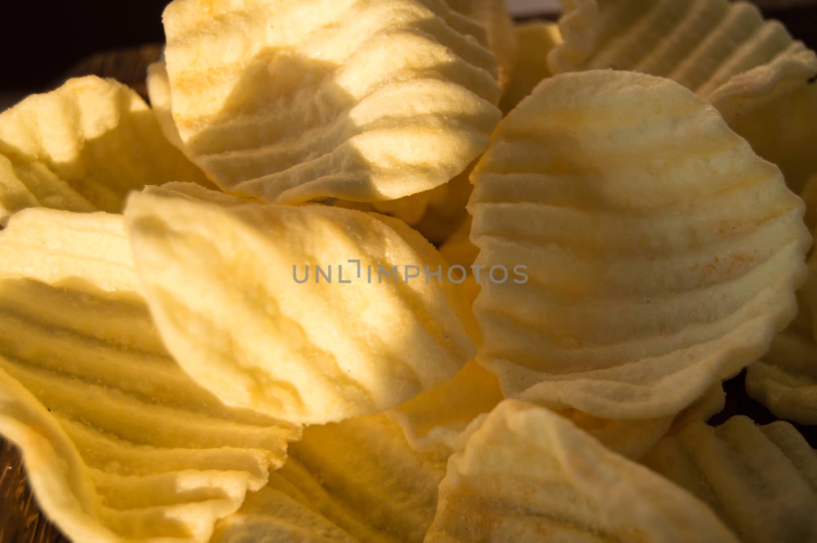 Yellow salty potato chips in the background.
