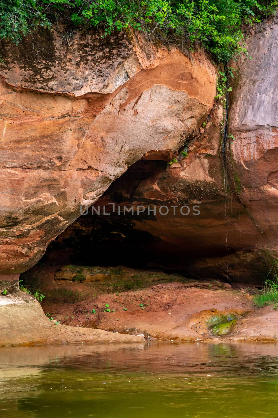 Red sandstone cliff on coast of the river  by fotorobs