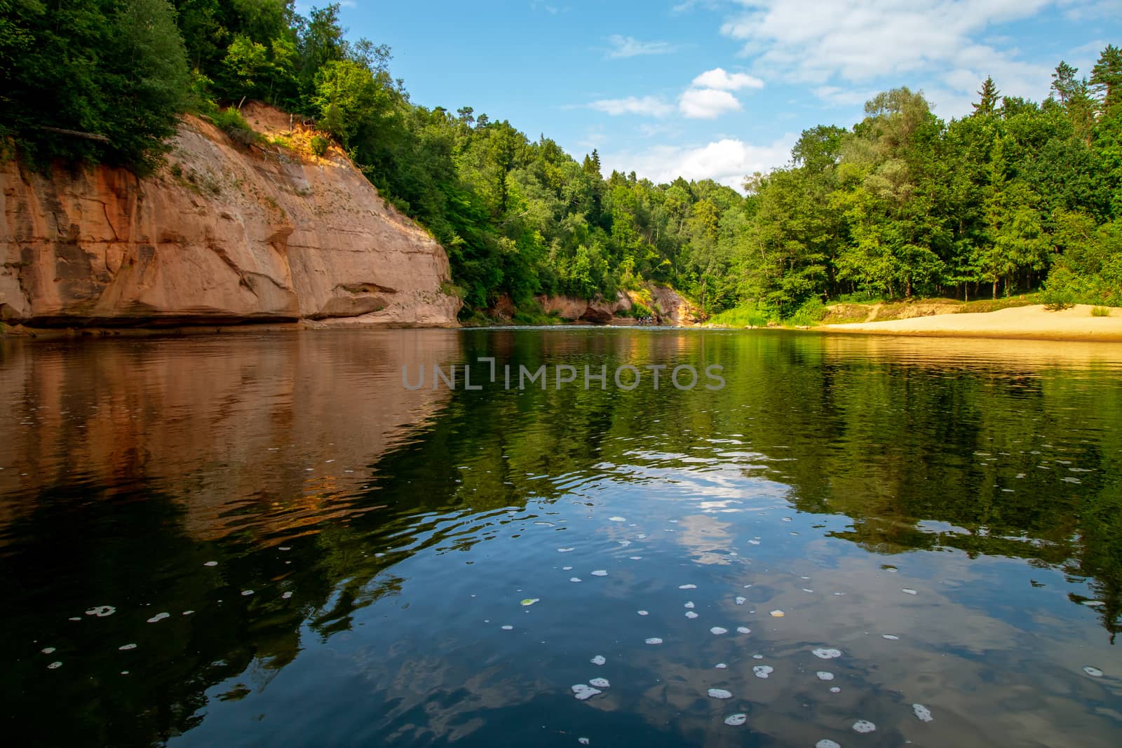 Landscape with cliff near the river Gauja, forest and clouds reflection in water. The Gauja is the longest river in Latvia, which is located only in the territory of Latvia.