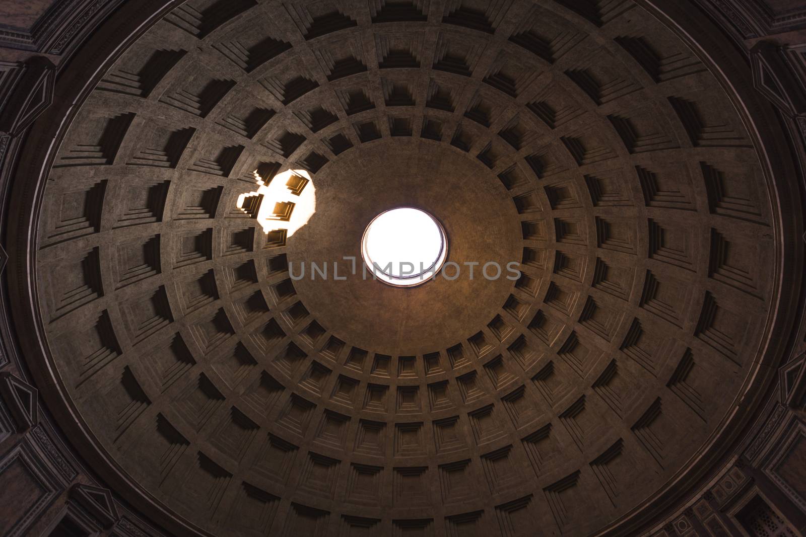 Pantheon dome as seen from inside the Pantheon with a visible light beam coming through the oculus, or open hole. The dome is nearly 2000 years old and the world's largest unreinforced concrete dome.
