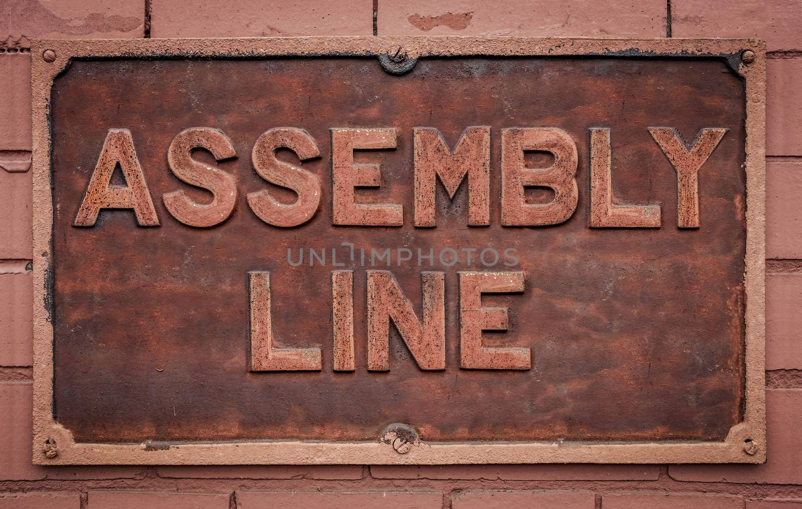 A Grungy Metal Sign For A Manufacturing Assembly Line