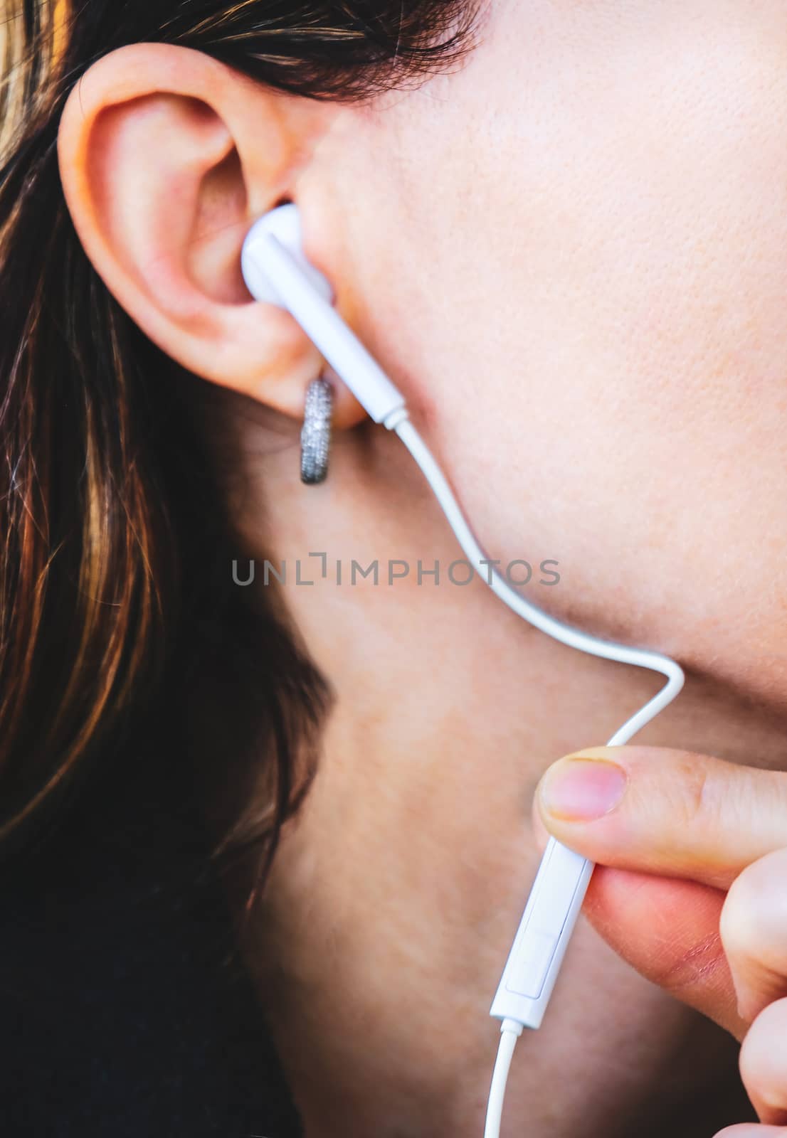 touching earphone press volume strength close woman audio isolation by LucaLorenzelli