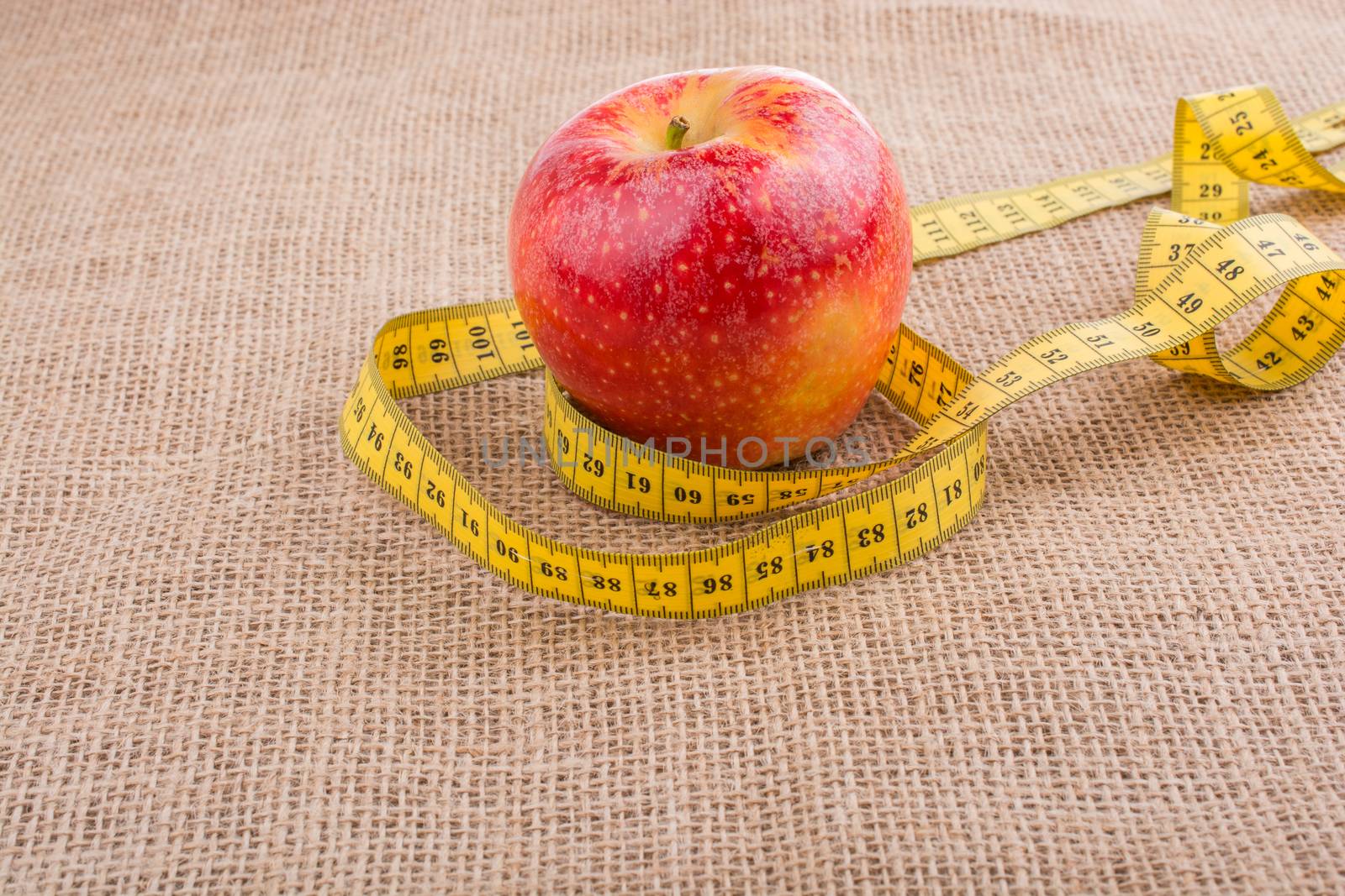 Red apple with a measurement  tape on it by berkay