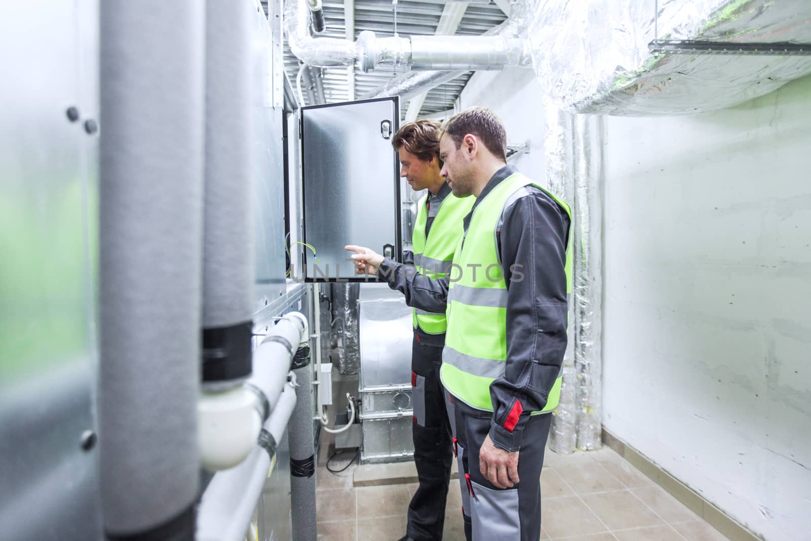 Two engineers working on the checking status switchgear electrical energy distribution substation