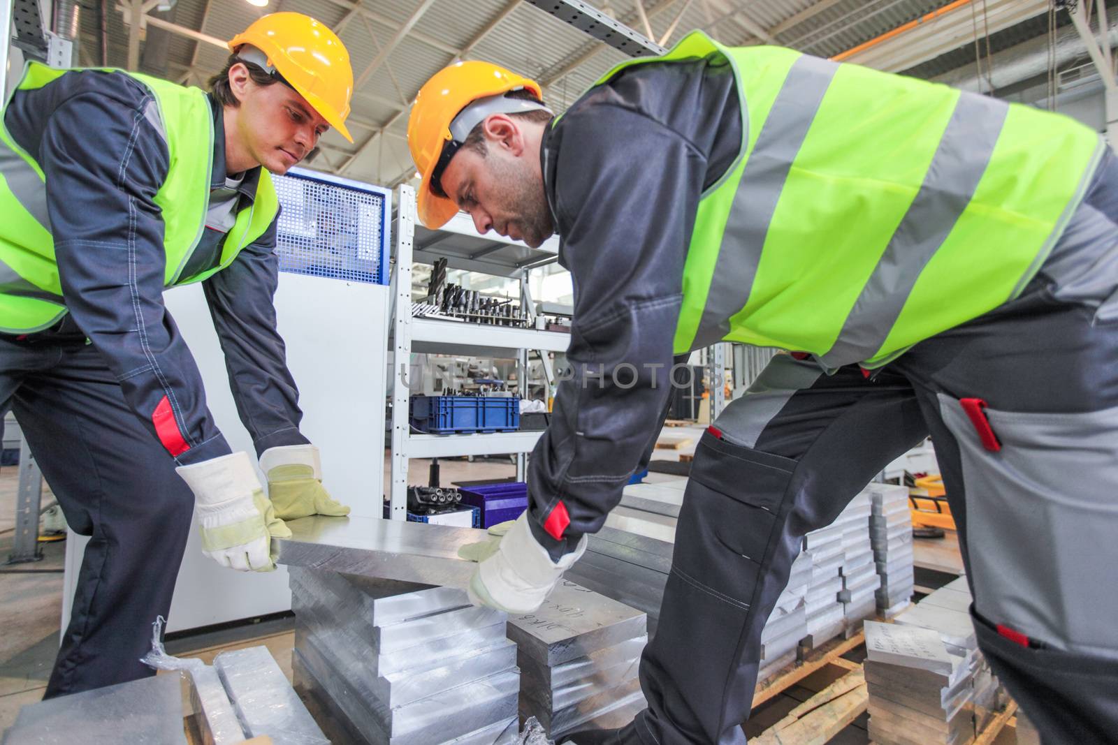 Workers taking aluminium billet at CNC machine shop