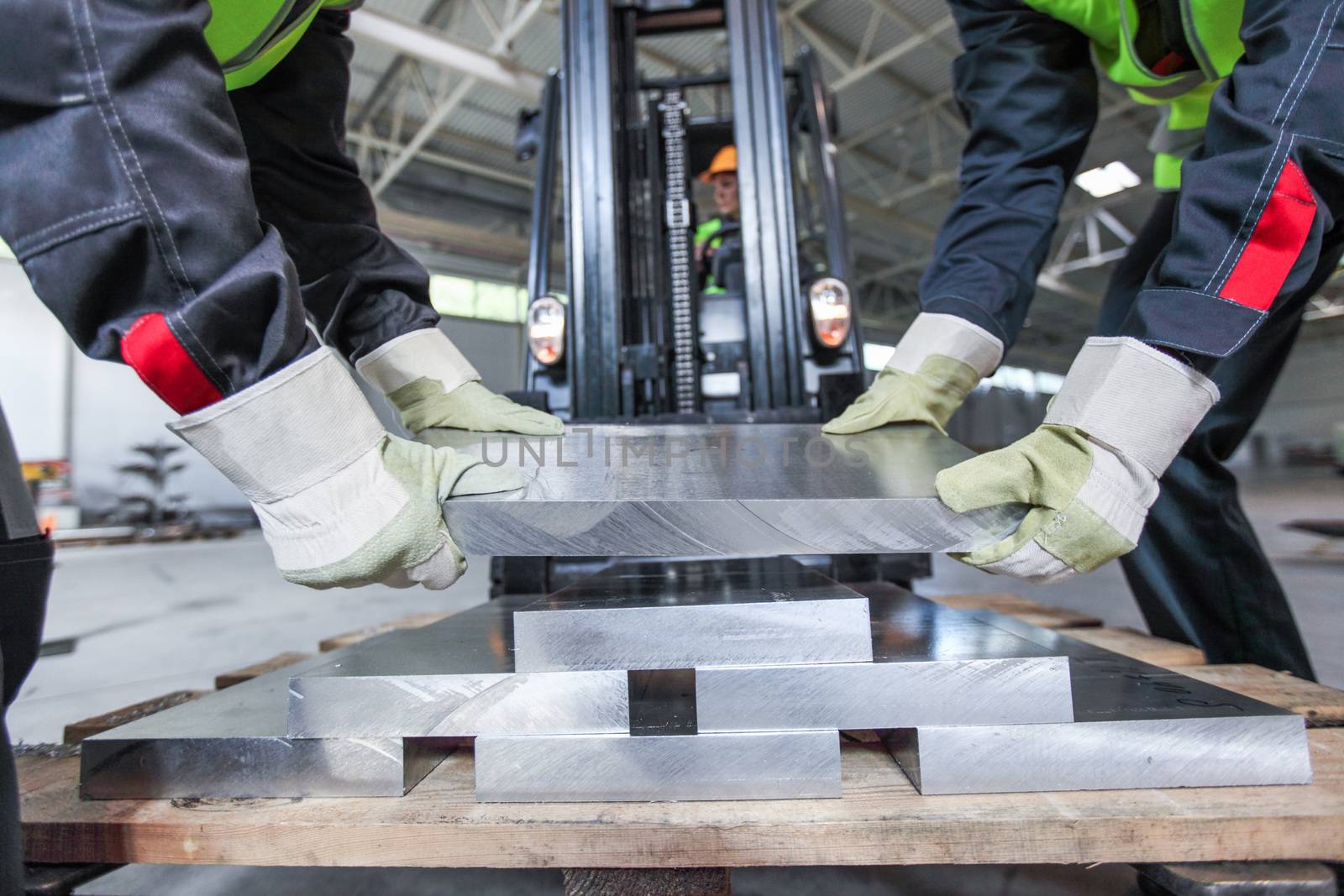 Workers taking aluminium billet at CNC machine shop