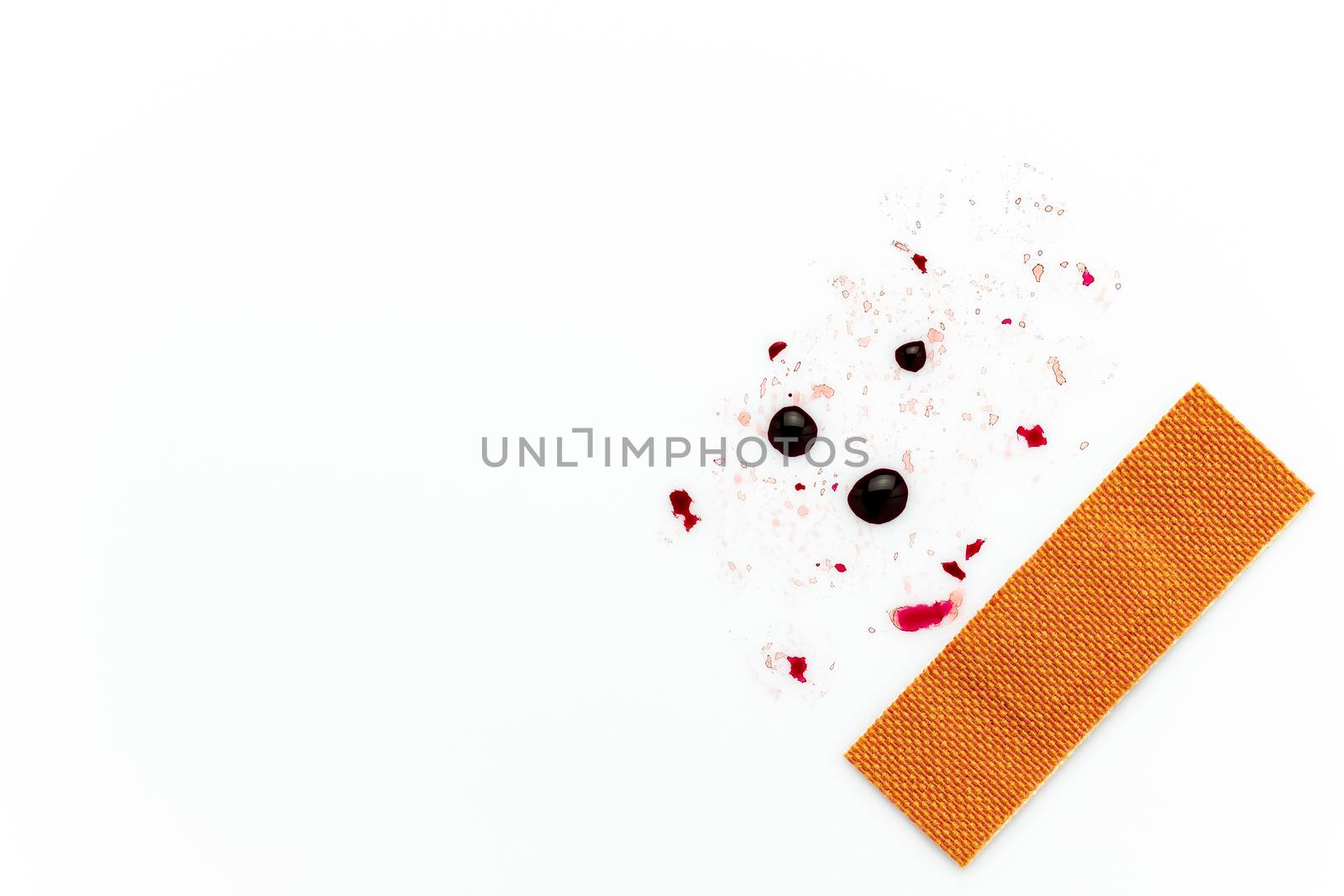 Brown wound plaster and droplets of fake blood on a white background. Copy space for text or articles. Concepts of health and medicine.