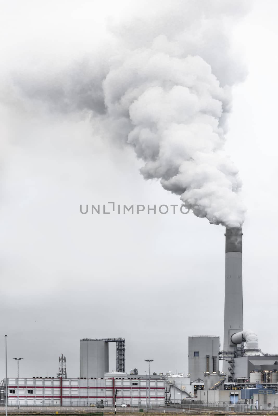 Tall chimney exhausting or pulling a huge quantity of smoke, mist or pollution, Rotterdam, Netherlands
