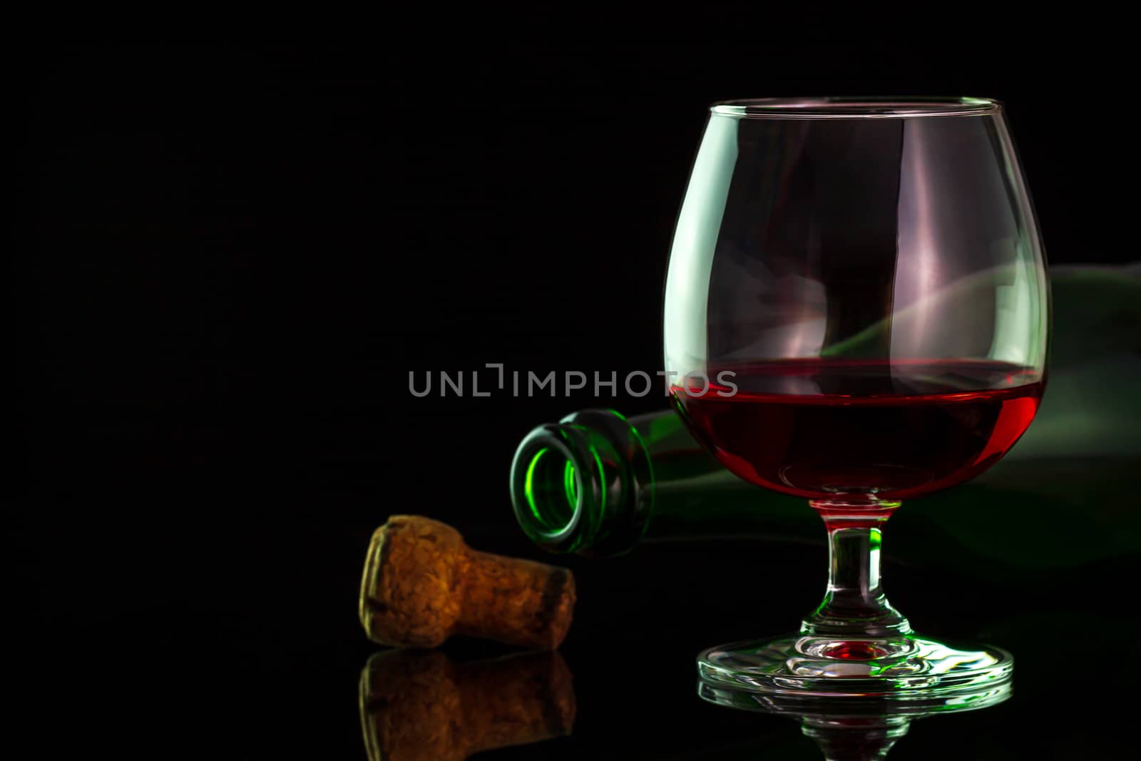 Red wine in glass and bottles on the table in darkness backgroun by SaitanSainam