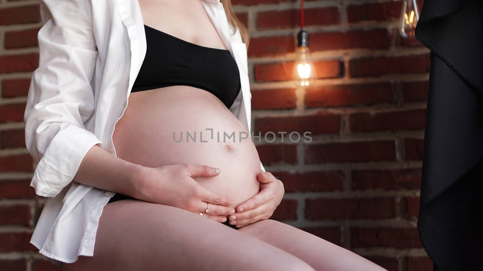 Pregnant Woman holding her hands on her baby bump by natali_brill
