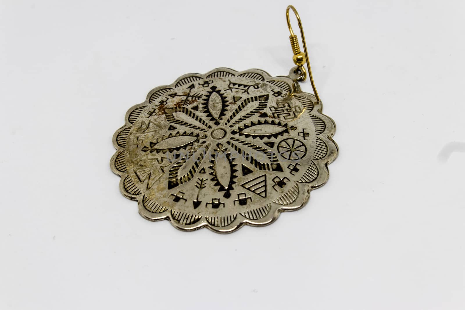 a good looking old silver badge with flower pattern with white background.