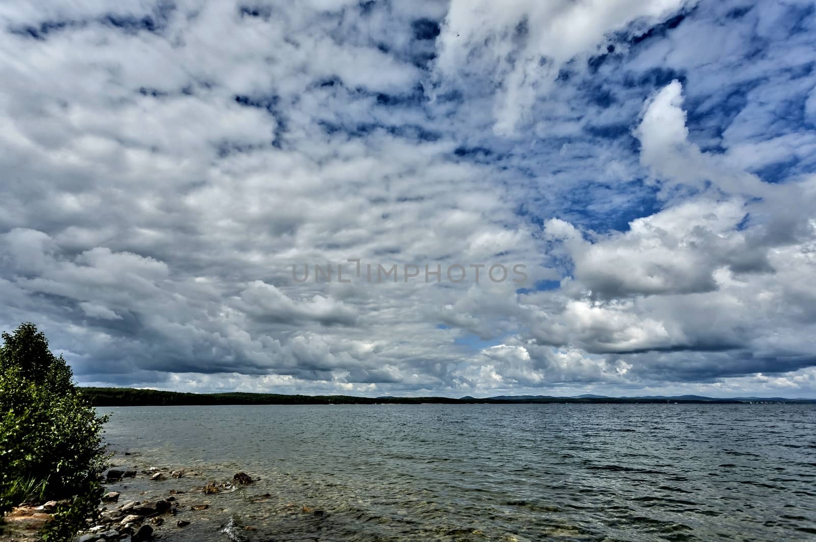 day lake in gray-white cloudy weather, South Ural, Uvildy, in the distance are seen the Ural mountains