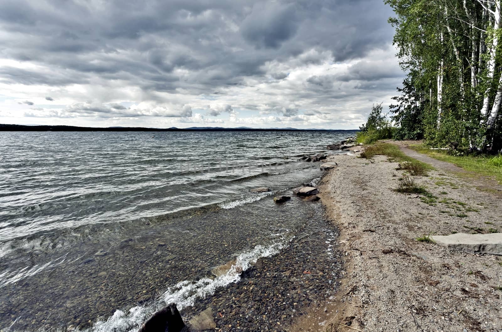 view of the lake with cumulonimbus clouds above it by valerypetr