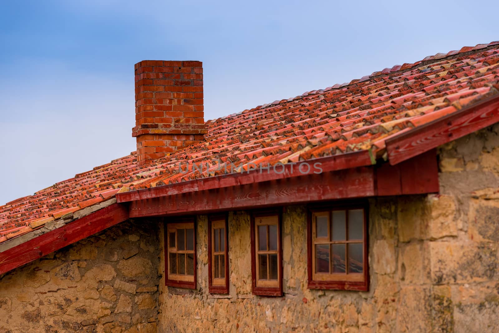 roof of a rural house close up against blue sky by kosmsos111