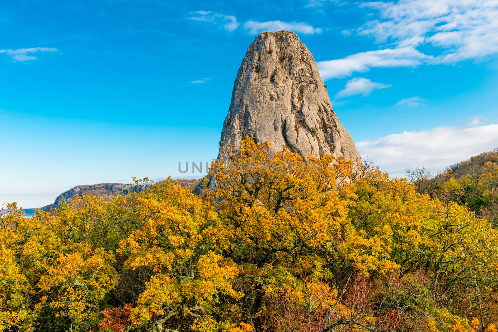 High rock surrounded by a yellow autumn forest in the mountains by kosmsos111