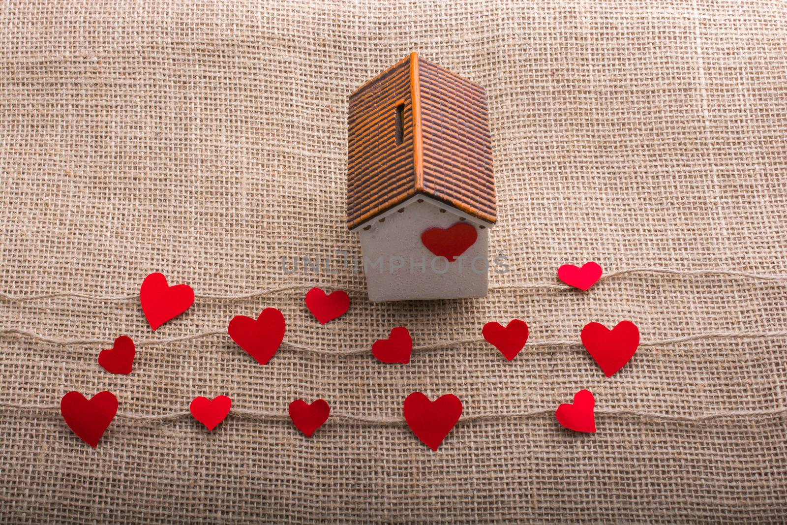 Heart shaped icons and paper house on linen threads