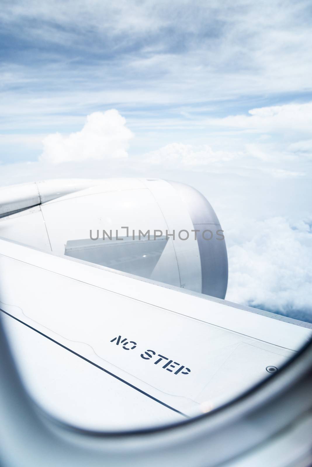 No step sign on commercial airplane wing, airplane in flight, shot through the window.