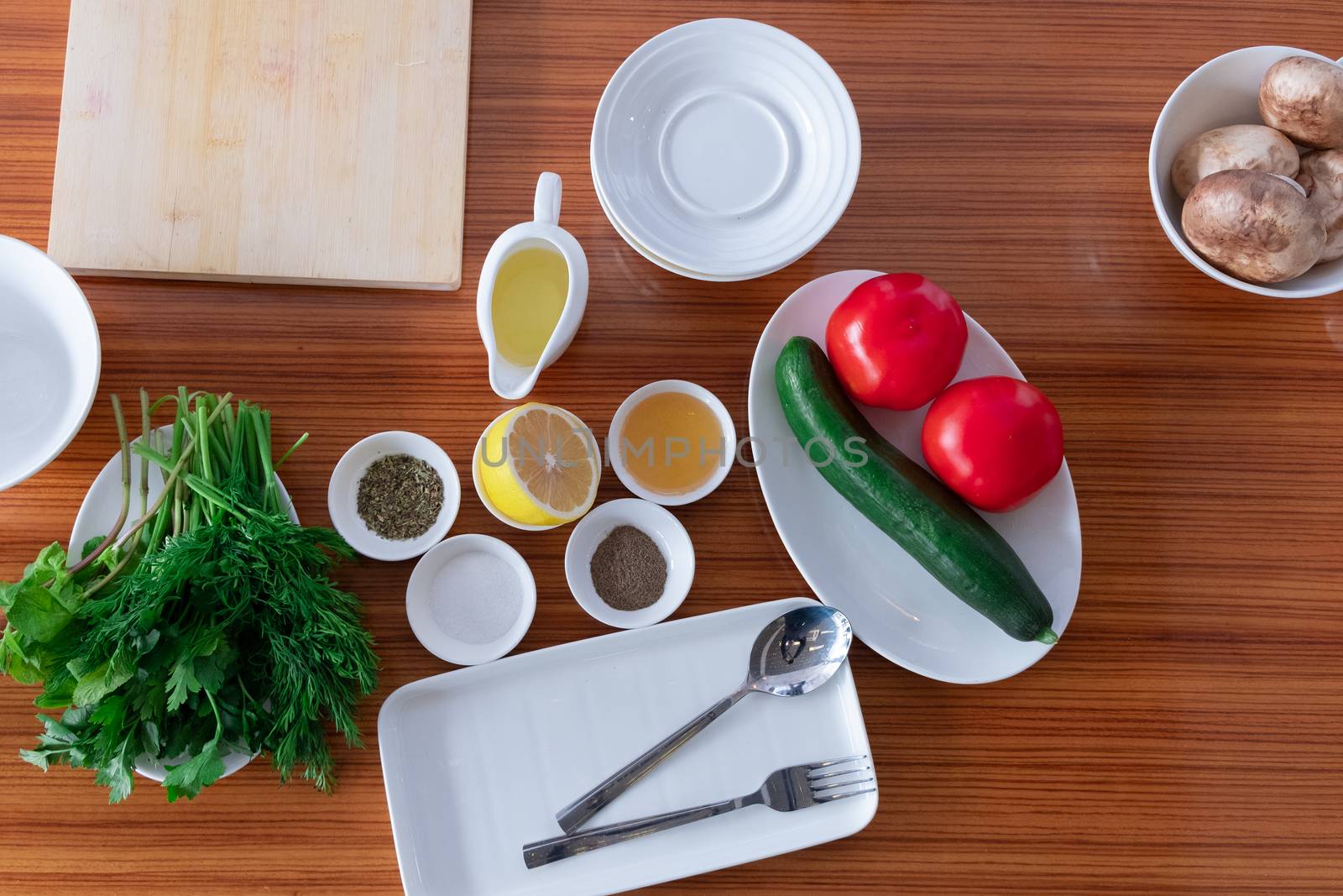 greens, cucumber, tomatoes, mushrooms and spices on the table. The view from the top.