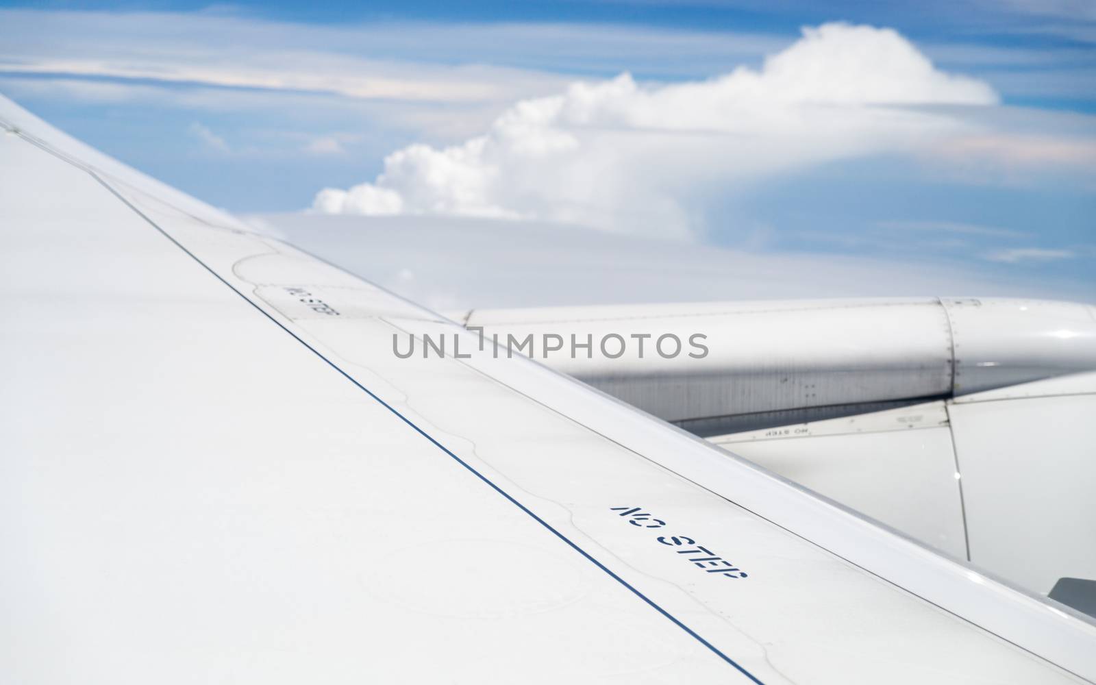 No step signs on commercial airplane wing, airplane in flight, shot through the window.