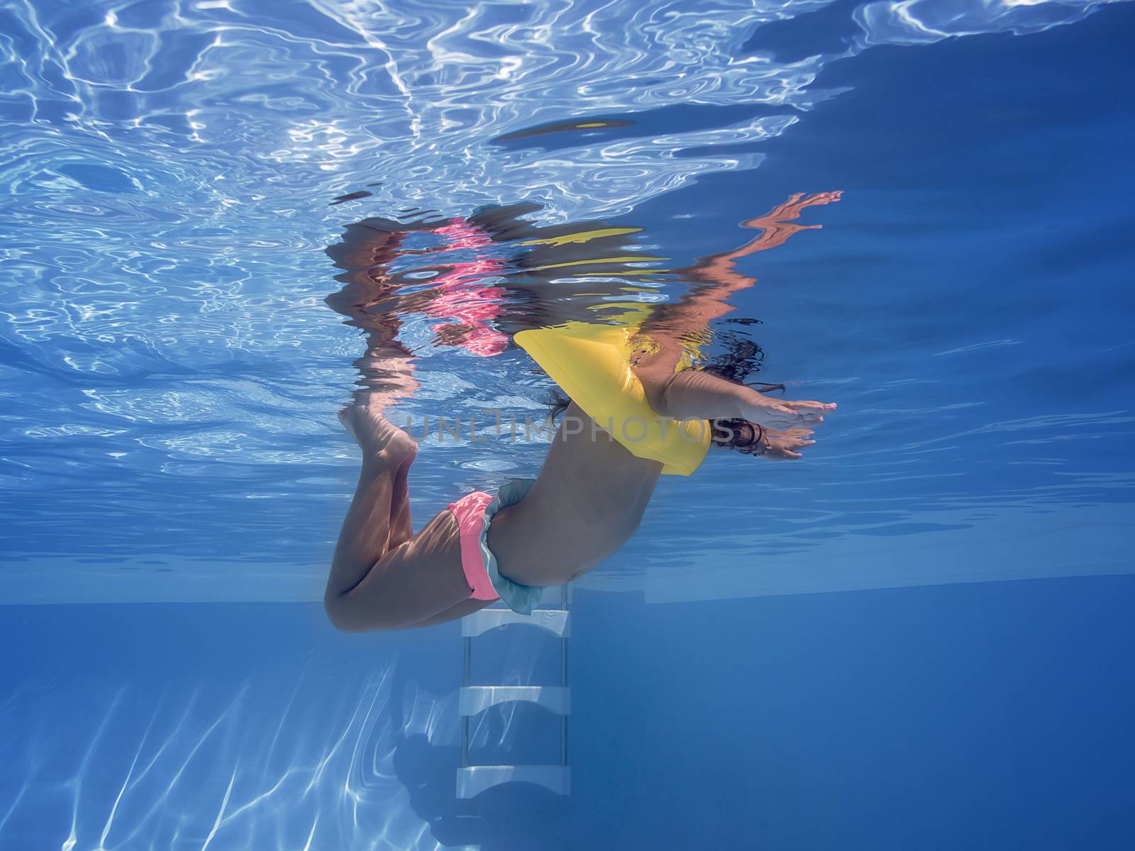 little girl swimming in the pool view under water by raulmelldo