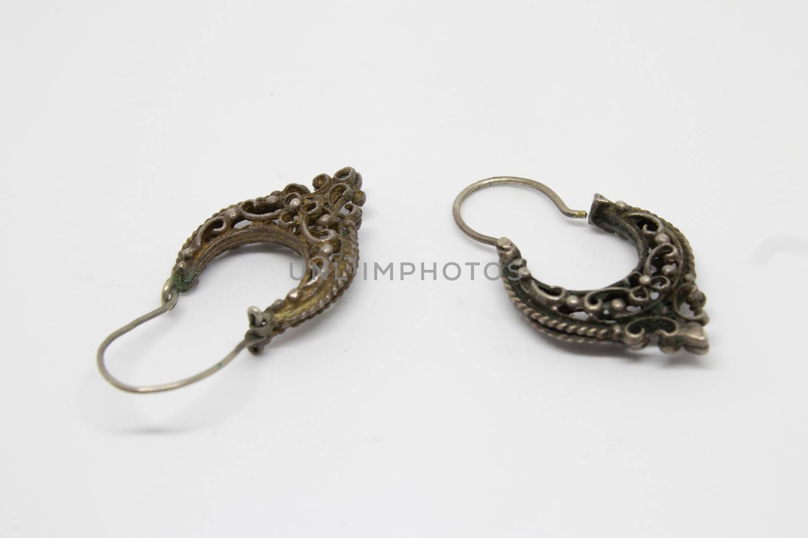 a pair of antique silver earrings closeup. photo has taken with photobox with white background.