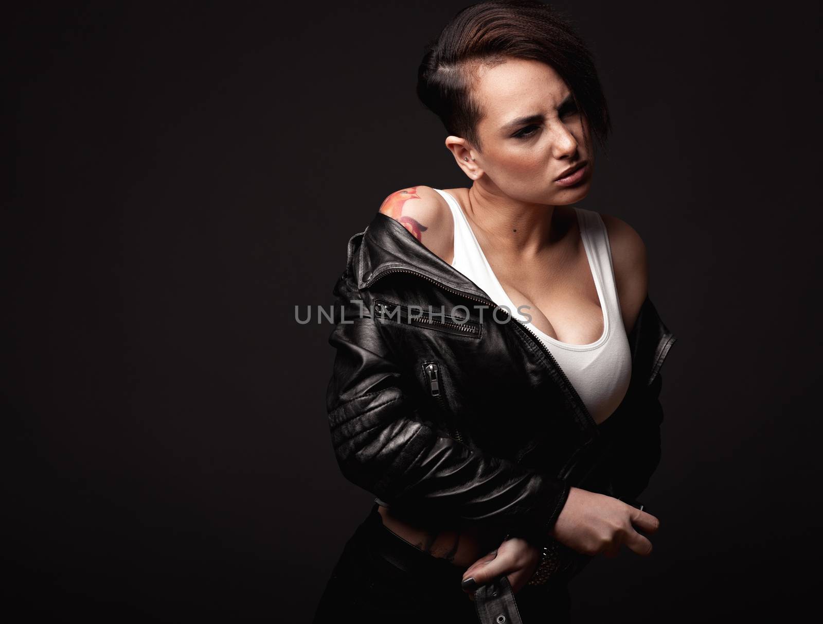 Beauty sexy woman in a leather jacket. Portrait on a dark background