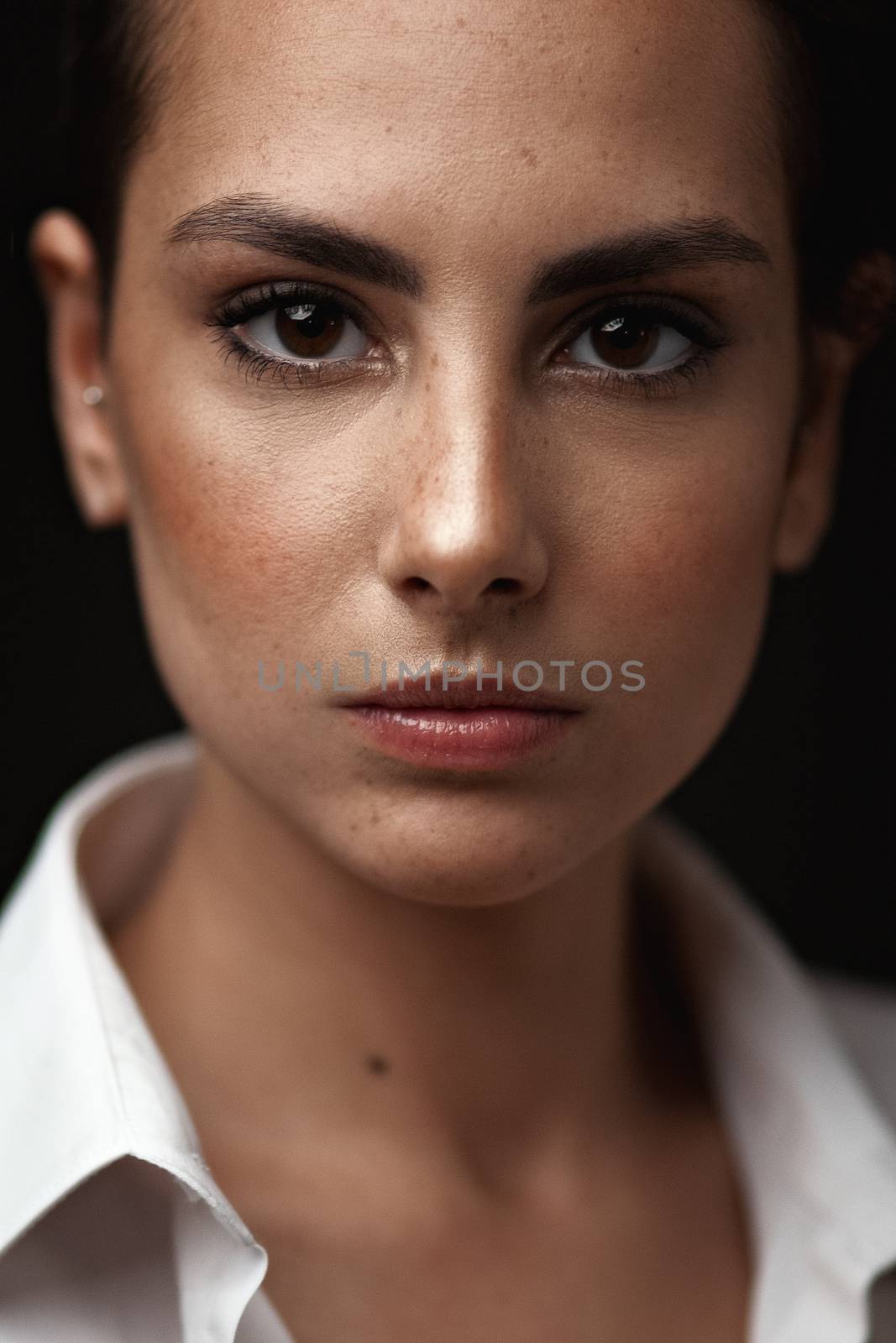 Beauty sexy woman in a leather jacket. Portrait on a dark background