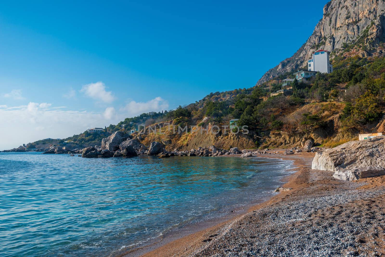 Coast of the sea bay, surrounded by mountains, sunny seascape