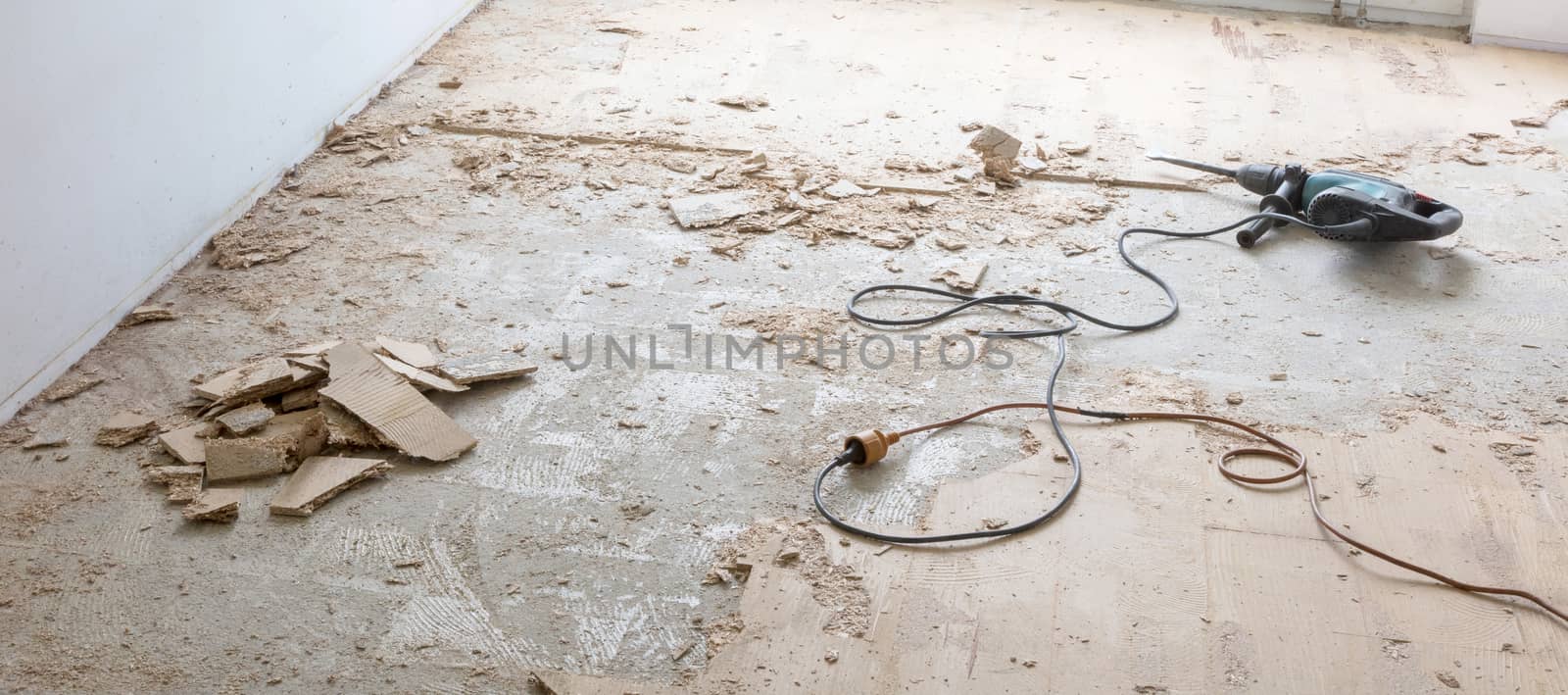 Construction concept - Jackhammer, removing chipboard from the floor - Selective focus