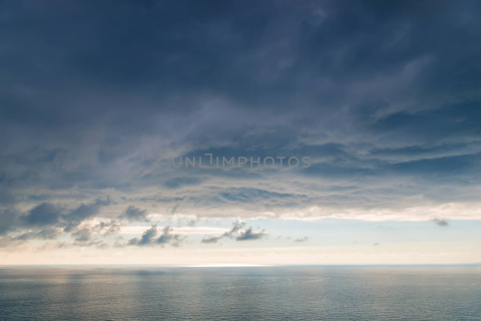 Large heavy black cloud dramatic sky above the sea surface of water