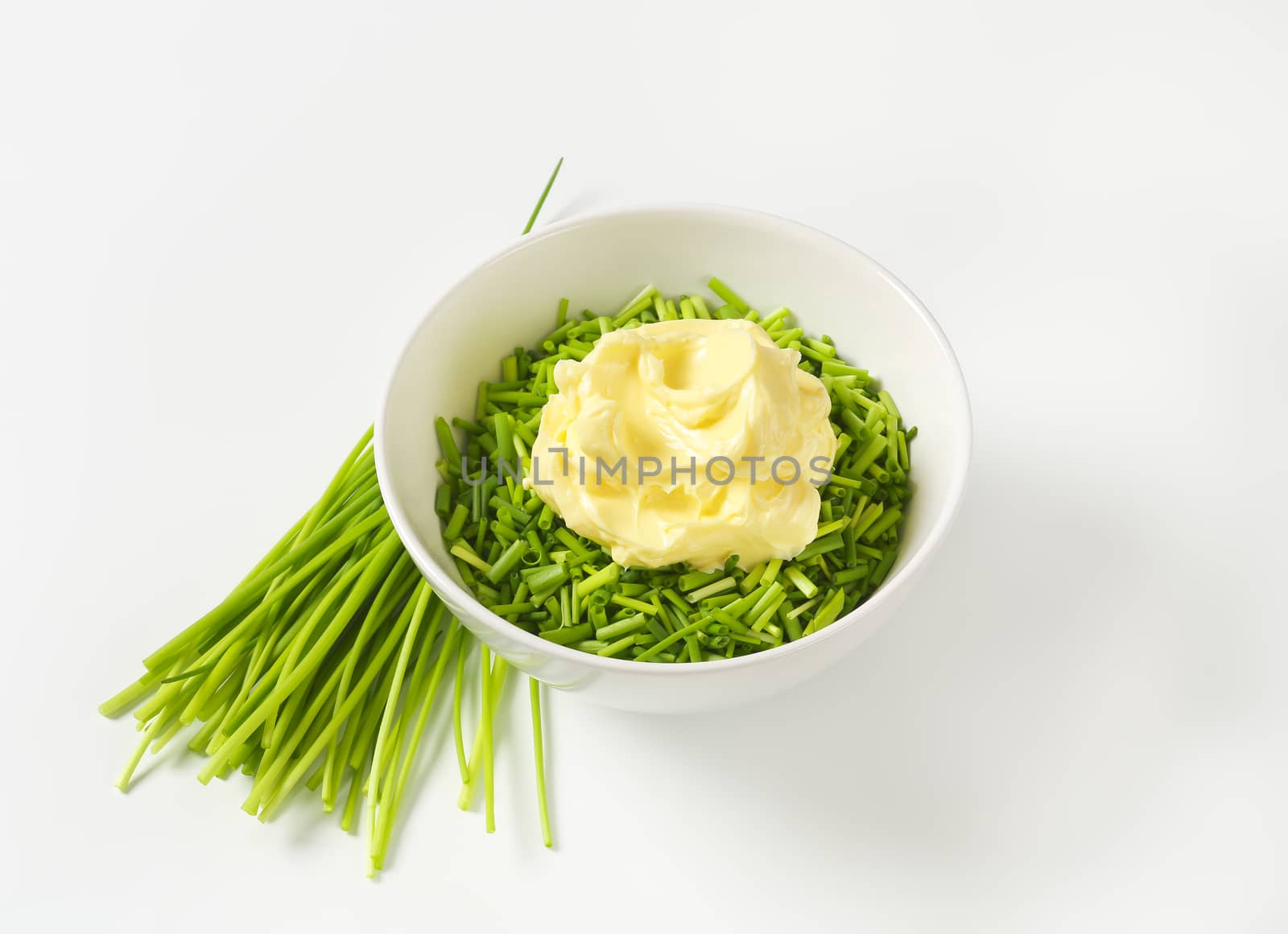 Chopped chives and butter in a bowl