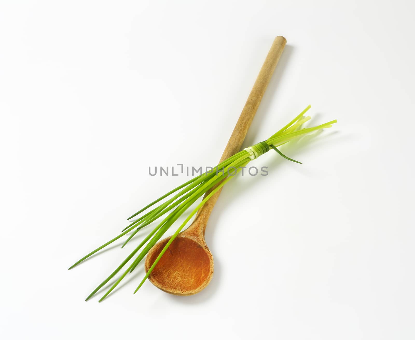 Bunch of fresh chives and wooden spoon