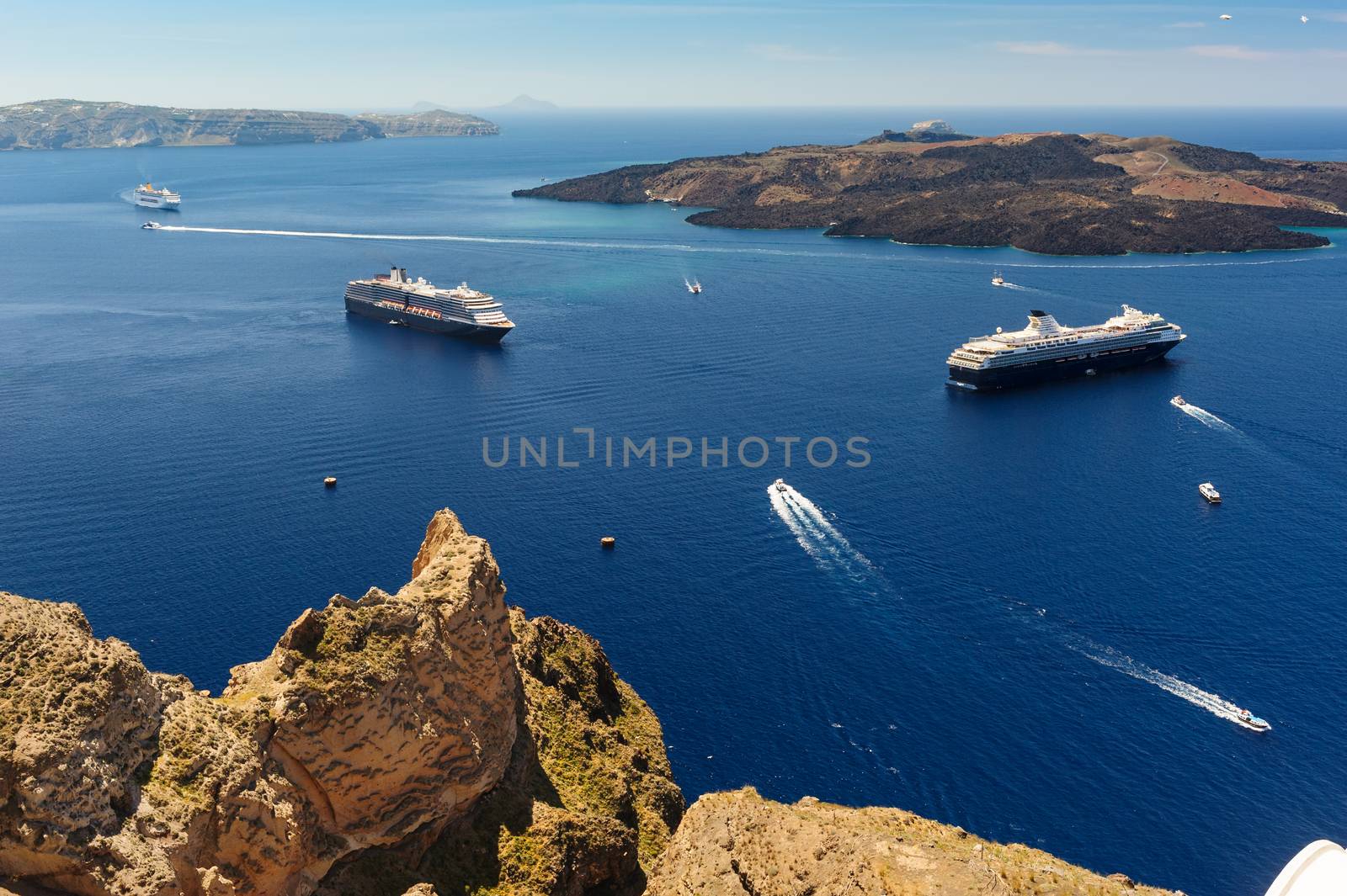 Typical view from Fira village to caldera sea with cruise ships at sunset, Santorini island, Greece