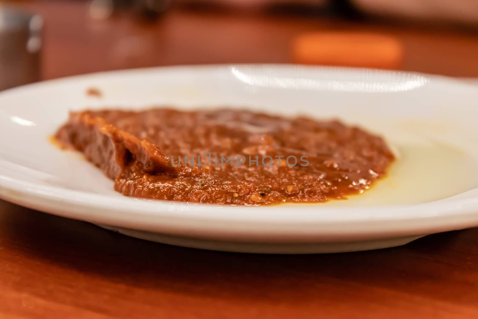 a closeup to red sauce with spicy pepper with plate. closeup food shoot taken at restaurant.