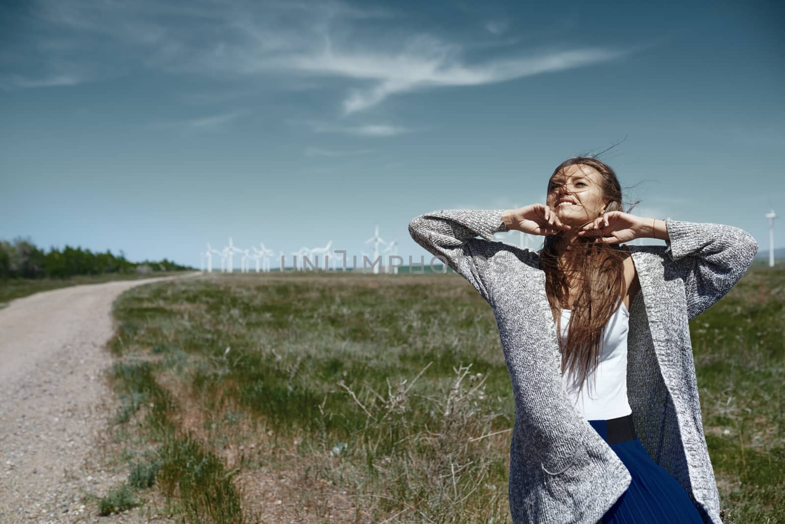 Woman with long tousled hair next to the wind turbine with the w by Novic