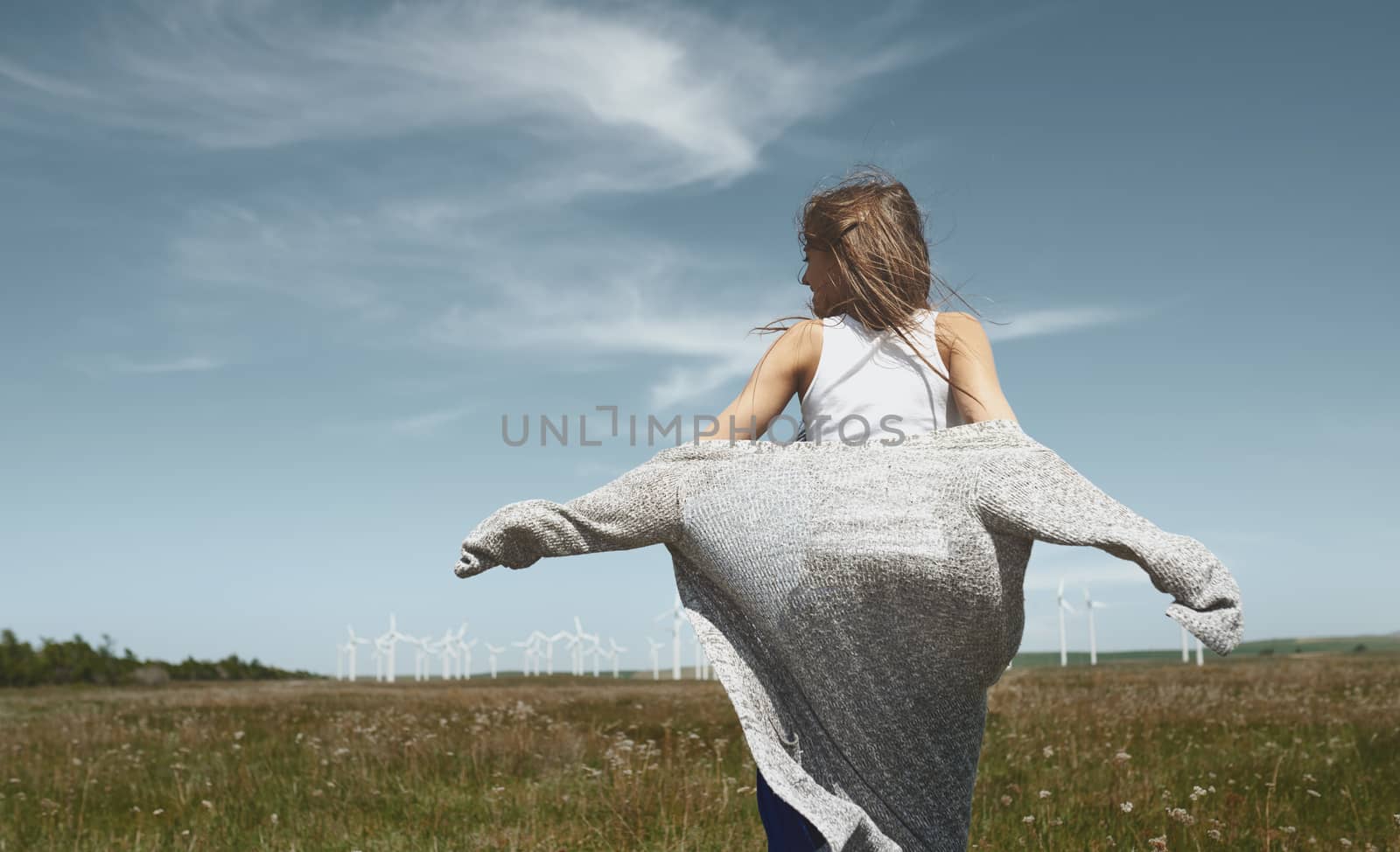 Woman with long tousled hair next to the wind turbine with the w by Novic