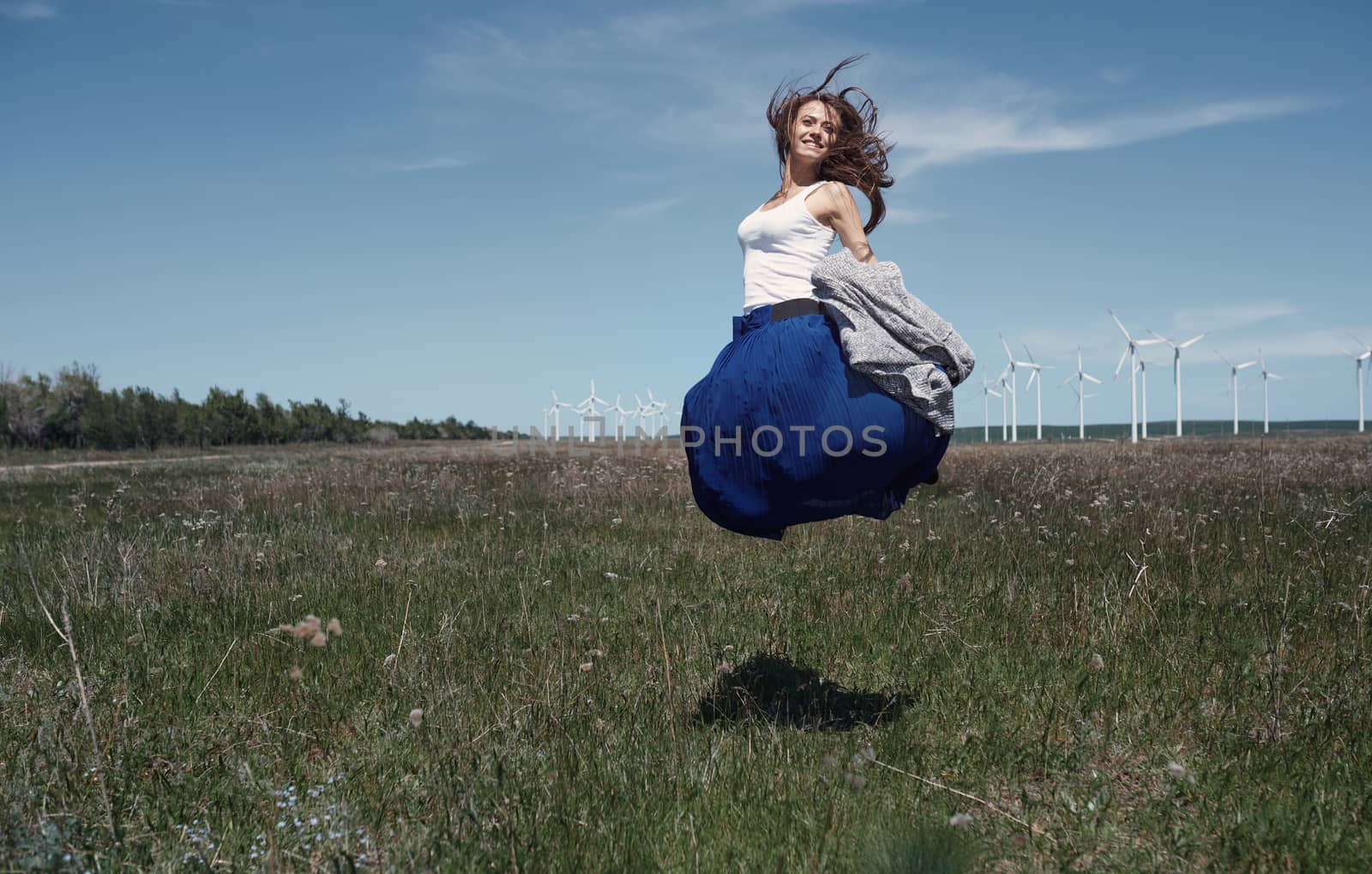 Woman with long tousled hair next to the wind turbine with the w by Novic