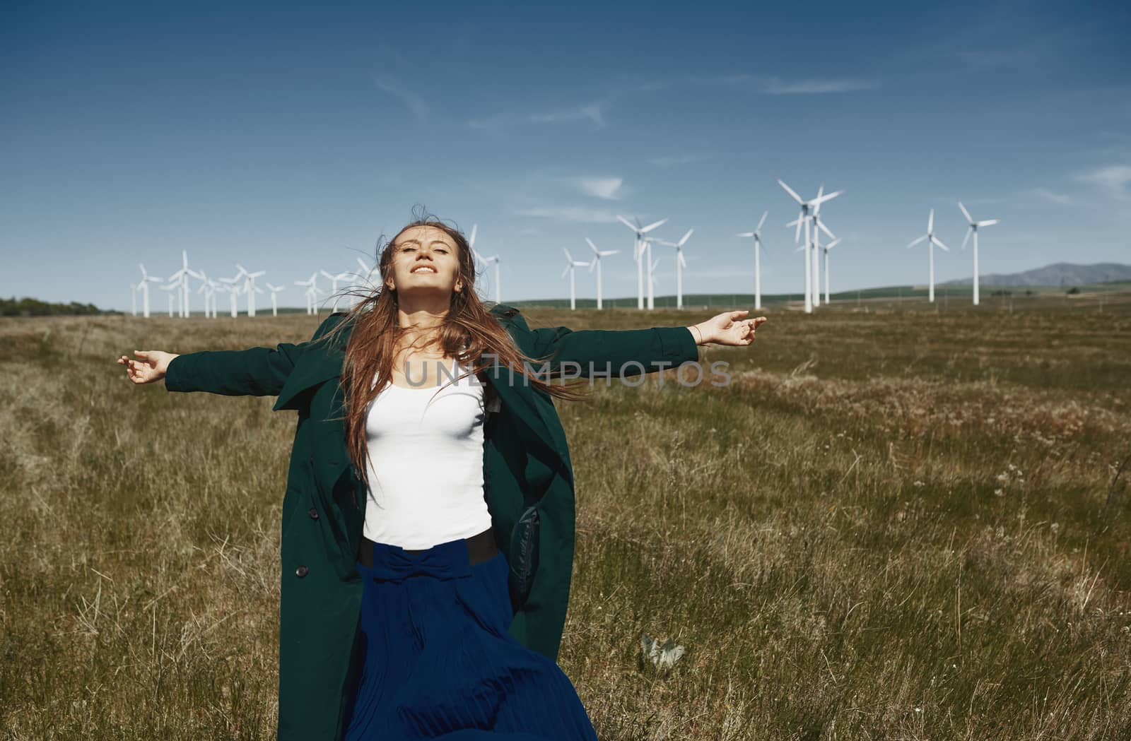 Woman with long tousled hair next to the wind turbine with the w by Novic