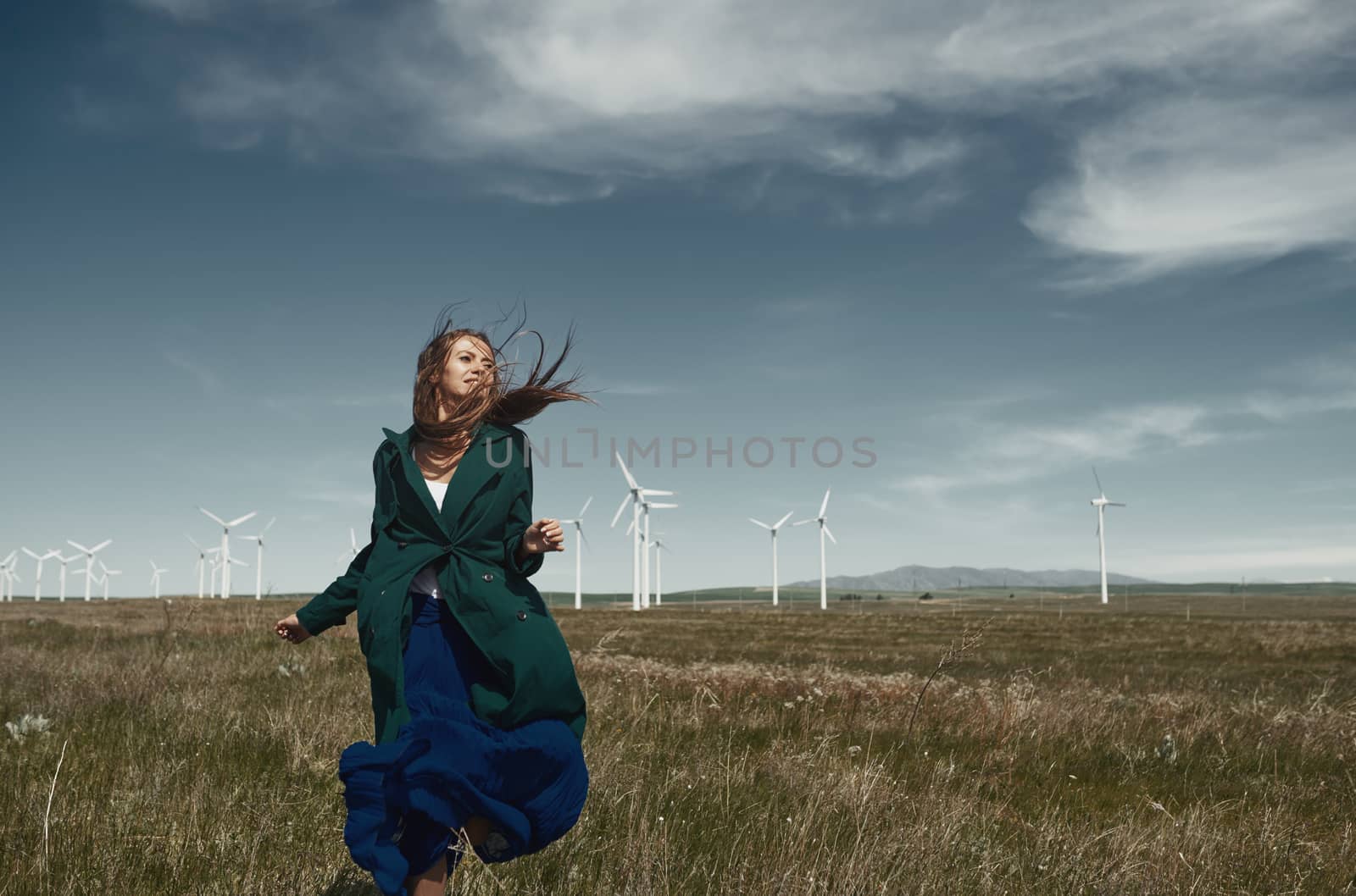 Woman with long tousled hair next to the wind turbine with the w by Novic