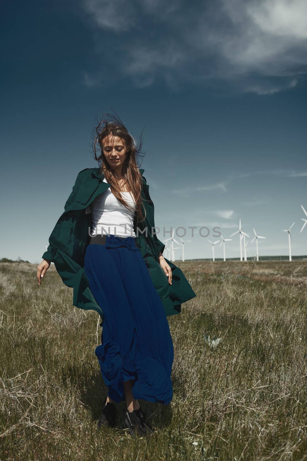 Woman with long tousled hair next to the wind turbine with the w by Novic