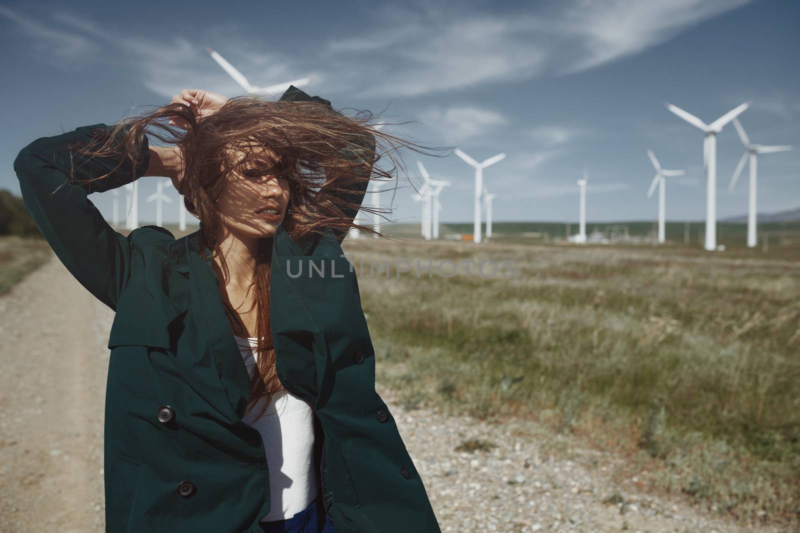 Woman with long tousled hair next to the wind turbine with the w by Novic