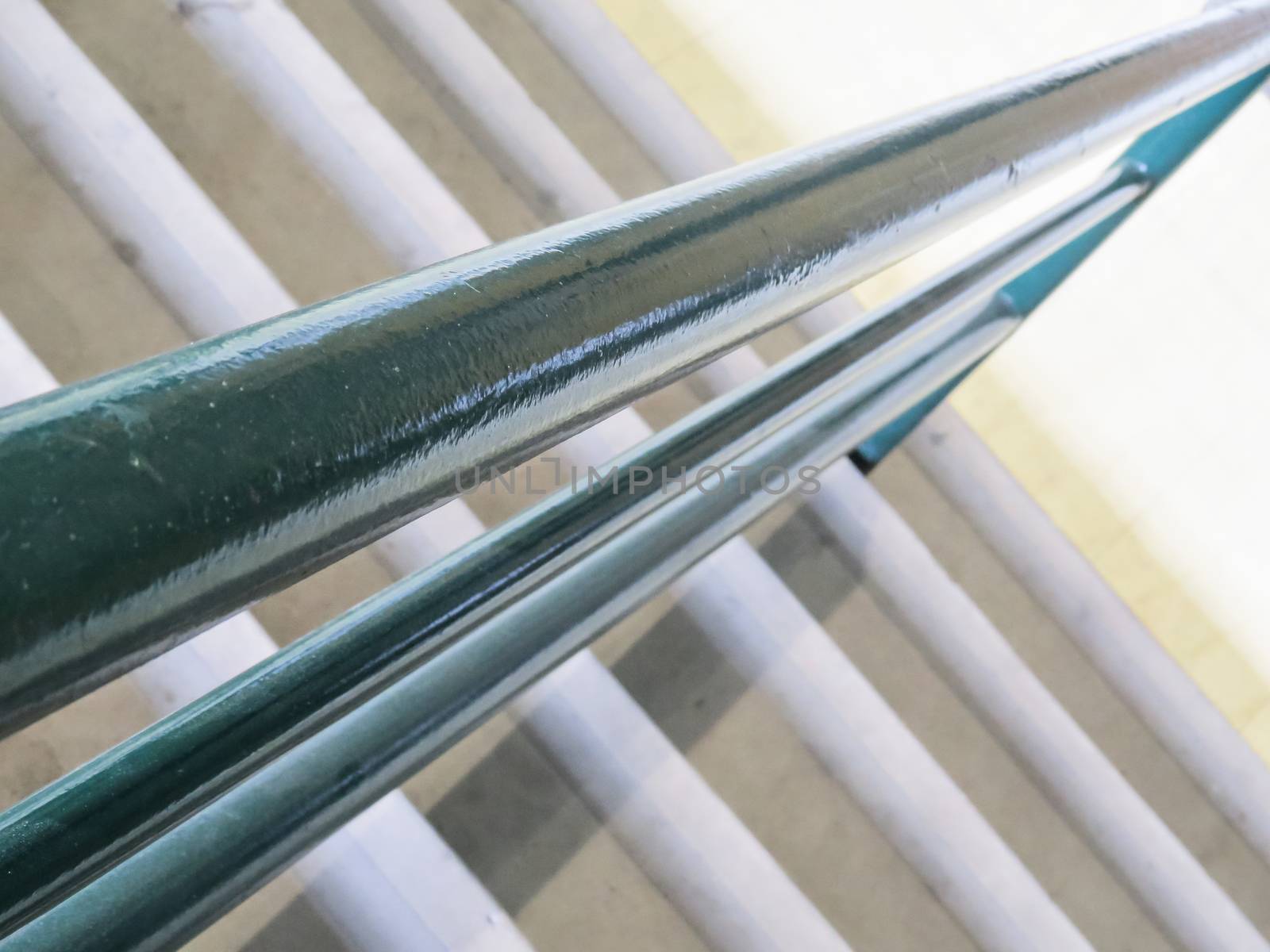 Bright blue banister on the diagonal, forming geometric and abstract figures, with white stairs in the background