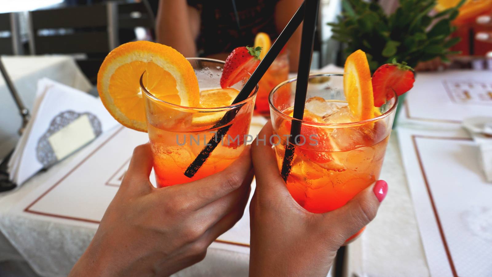 Young cheerful couple drinking Aperol Spritz cocktail in cafe in Milan