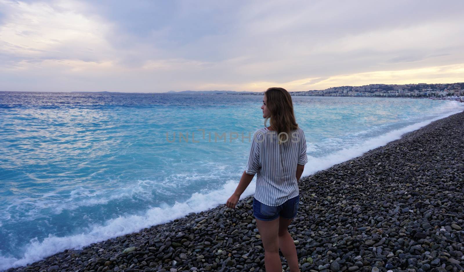 NICE, FRANCE. Young woman enjoying the azure coast and looking at the sea by natali_brill