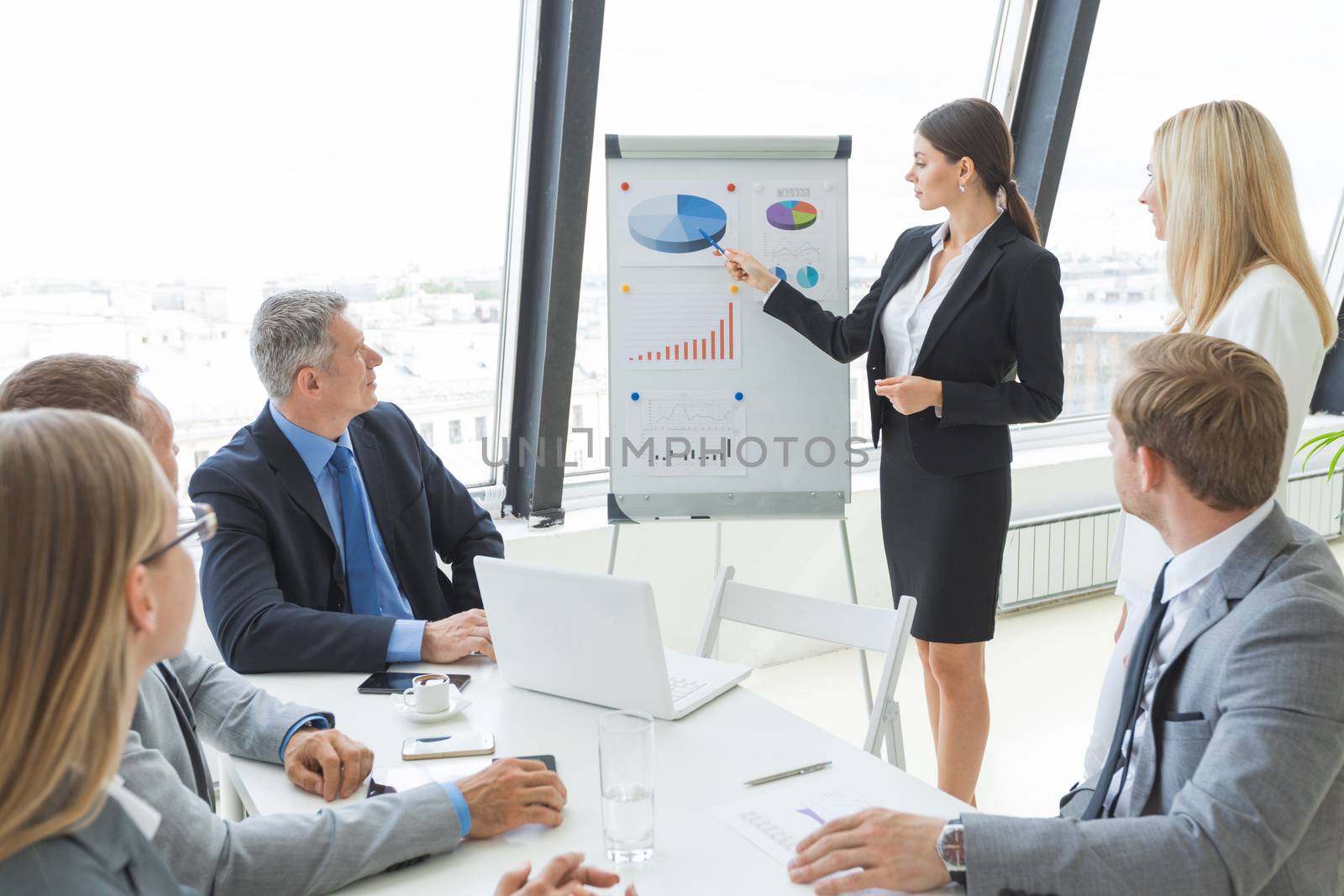 Businesswoman pointing at a chart on a whiteboard during business meeting