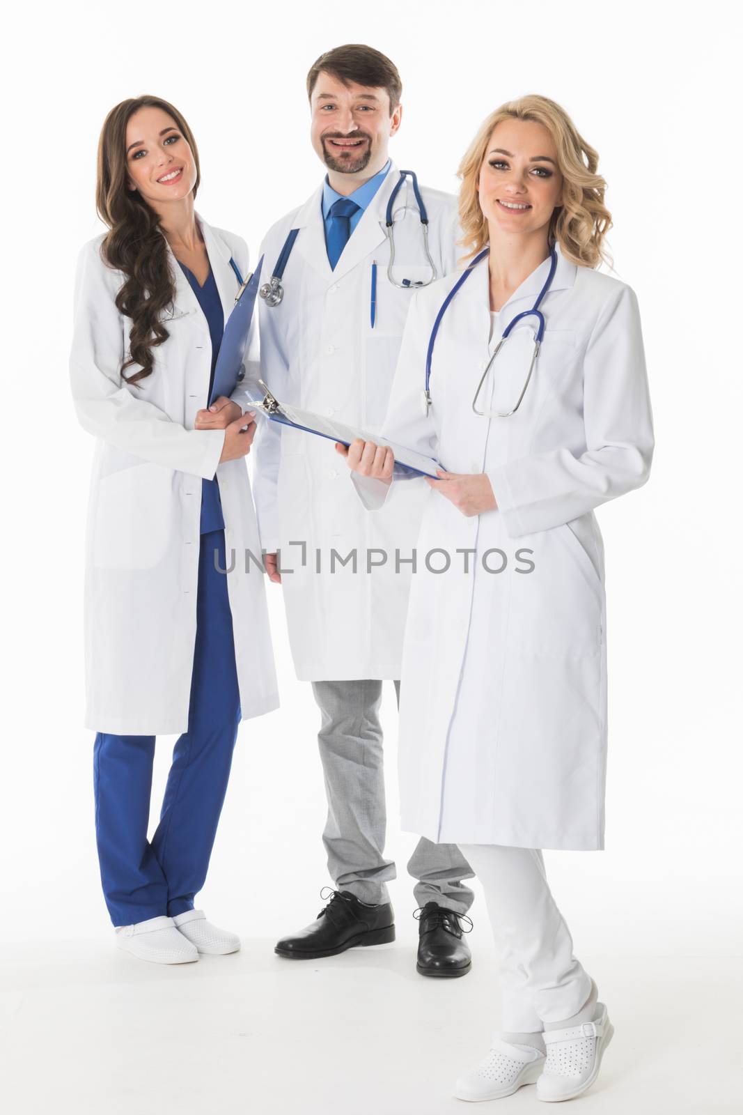 Successful team of medical doctors are looking at camera and smiling , studio isolated on white background